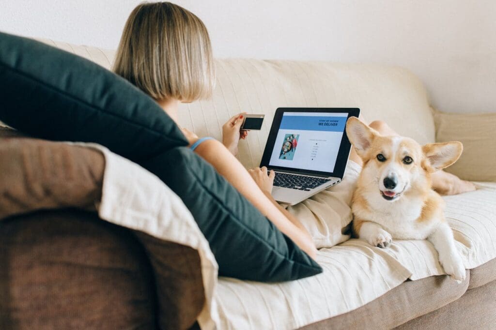 A woman reviewing website analytics on her laptop alongside her dog, working with an eCommerce consultant to boost online sales.